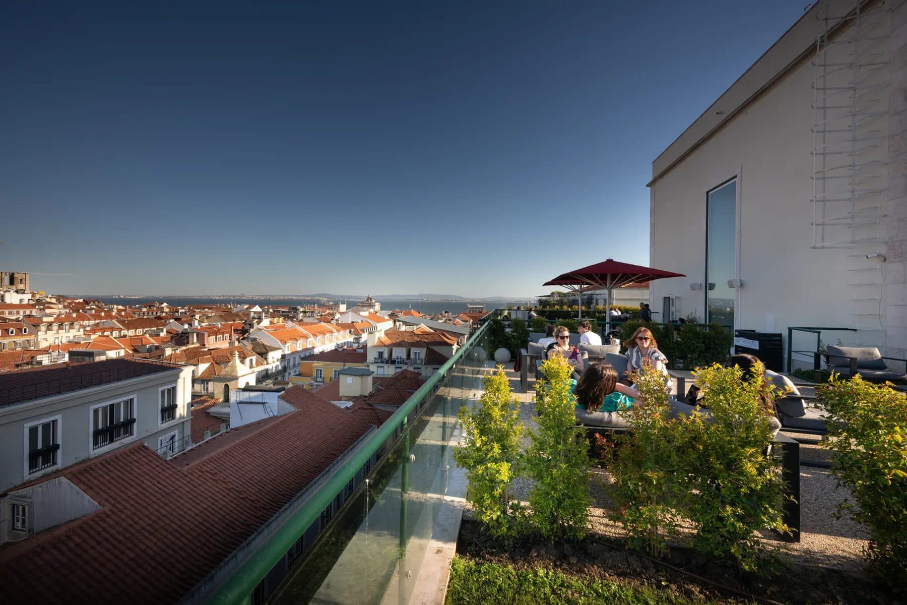 Seating and planters on Hotel do Chiado’s rooftop terrace above Lisbon.