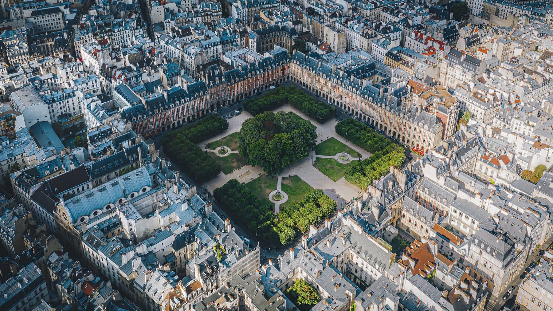Aerial view of the square garden and surrounding roofs at Place des Vosges.