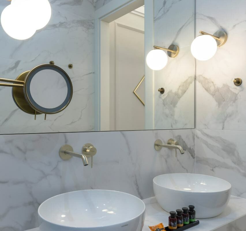 Two white countertop basins beneath a wide mirror in the Iconic Suite bathroom.