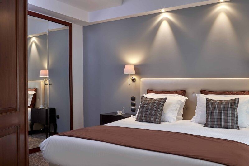 Double-bed arrangement against a blue wall in an AVA Executive Suite.