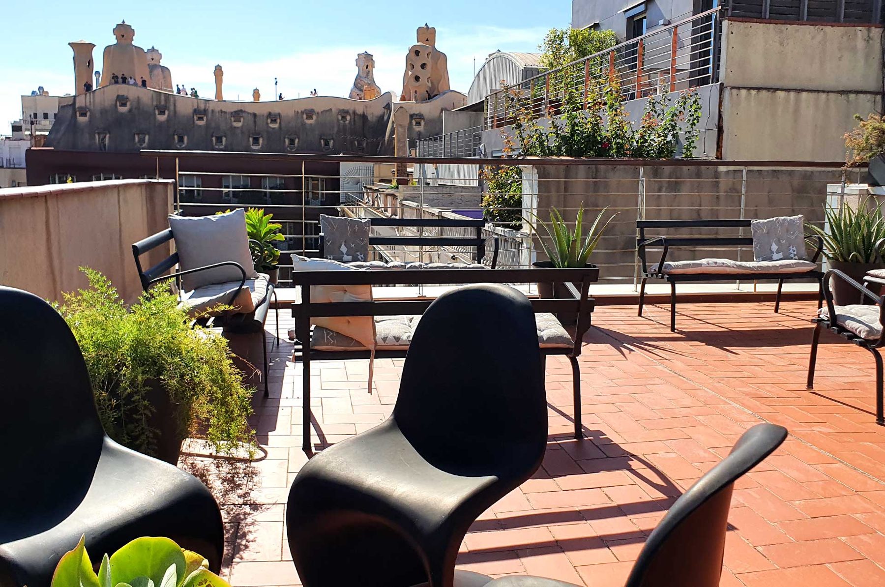 Hotel Actual’s shared rooftop terrace overlooking La Pedrera’s roof.