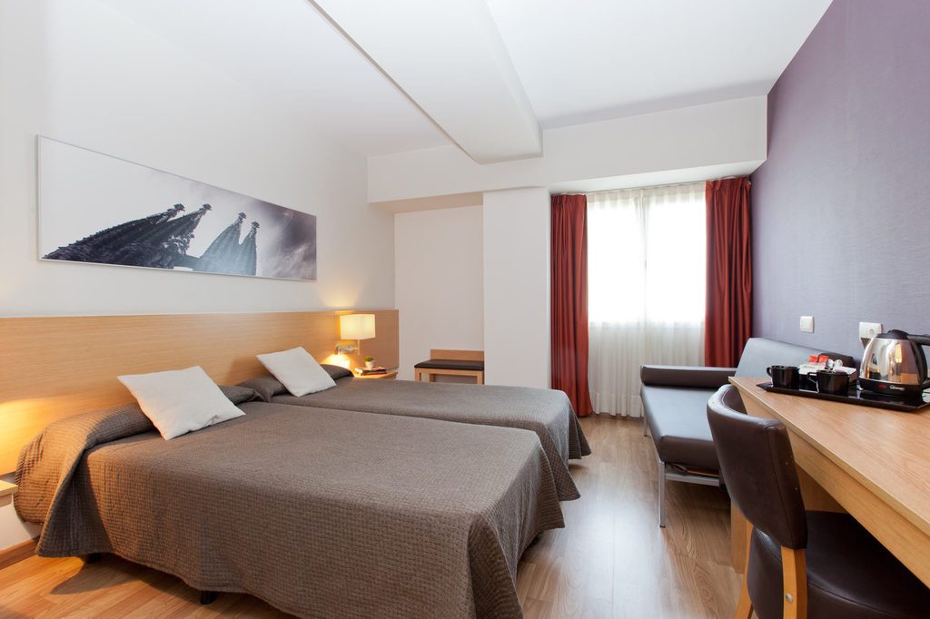Triple Room at Hotel Sagrada Família, with twin beds and a sofa.