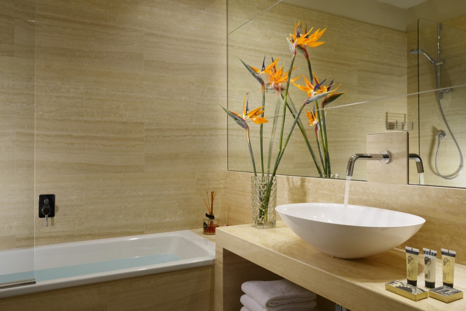 Beige bathroom with a bathtub and round basin.