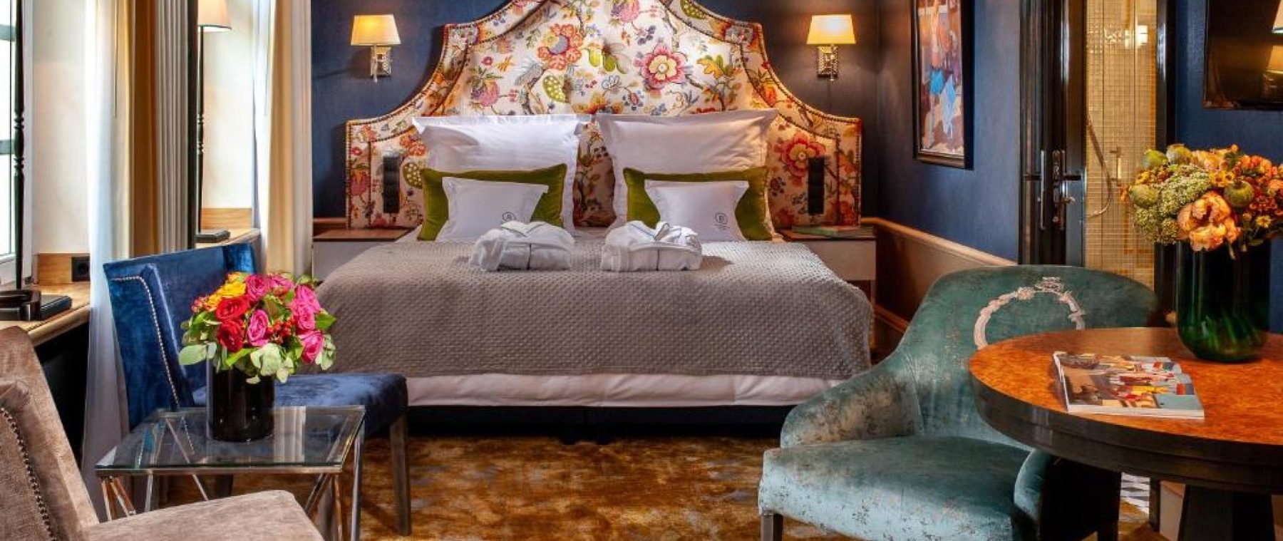 Balthazar Deluxe Double bedroom with a floral headboard and blue furnishings.