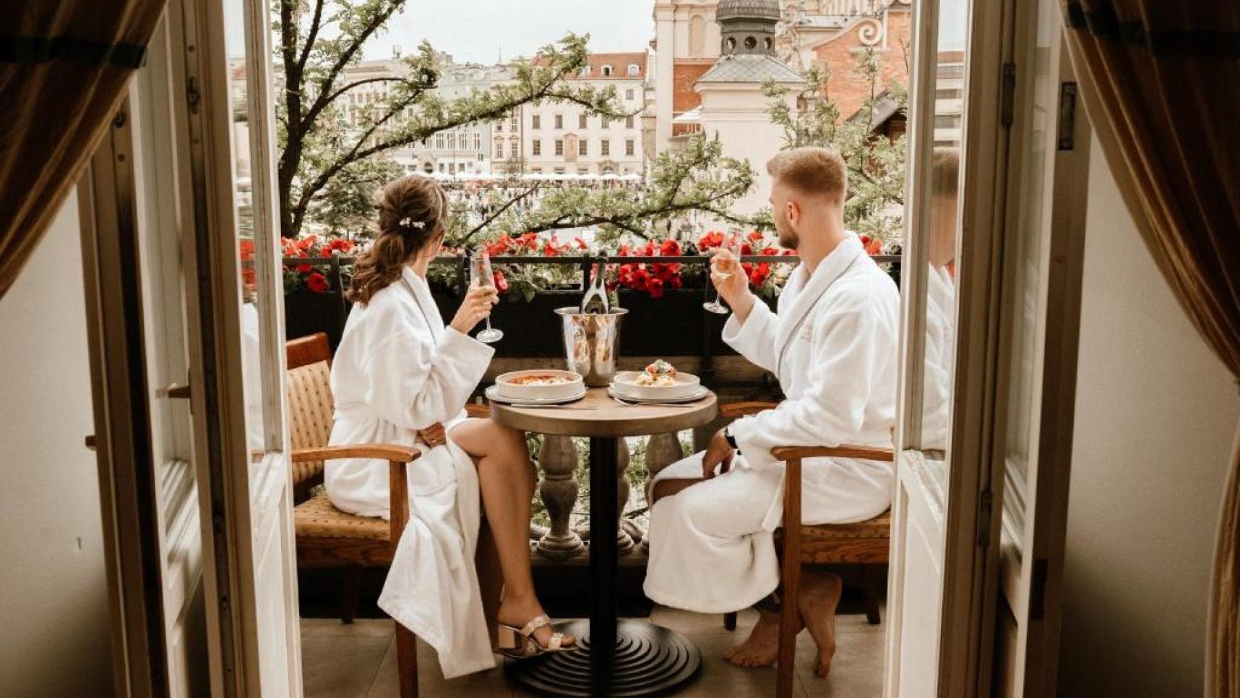 Flower-lined suite balcony overlooking the Main Market Square at Bonerowski Palace.