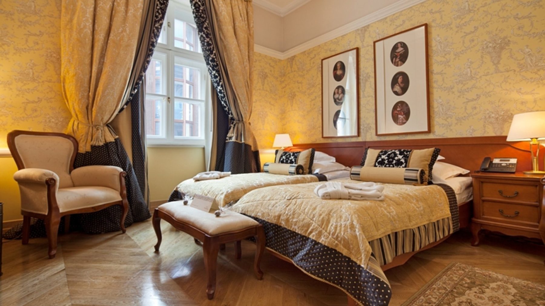 Bonerowski Palace Studio Deluxe bedroom with twin beds and yellow patterned walls.