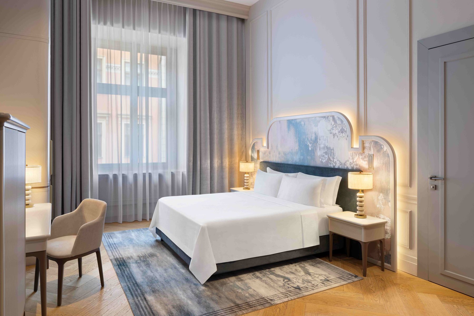 H15 Palace Junior Suite bedroom with a decorative headboard and tall window.