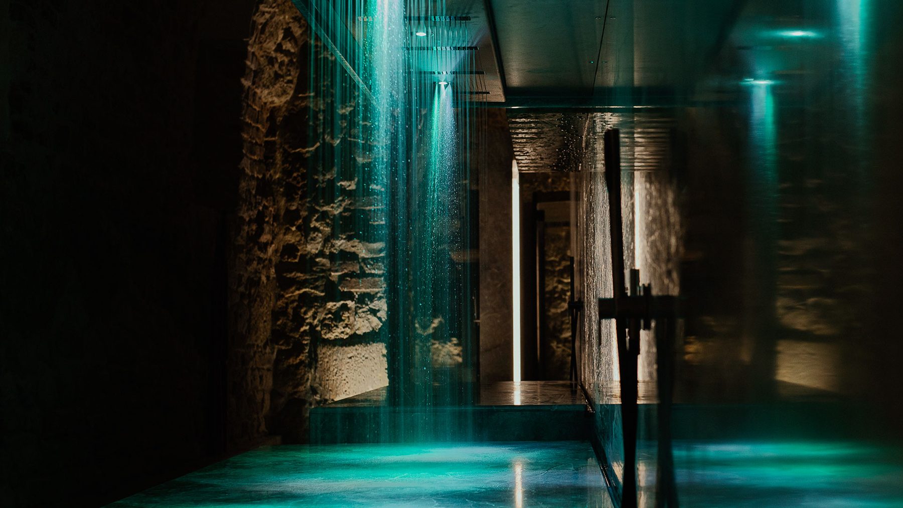 Water cascading beside stone walls in the Pod Różą wellness area.