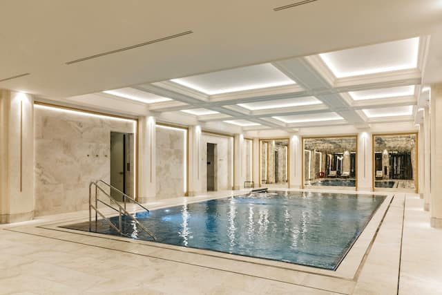 Indoor pool with pale stone walls and a mirrored backdrop at Hotel Saski Krakow.
