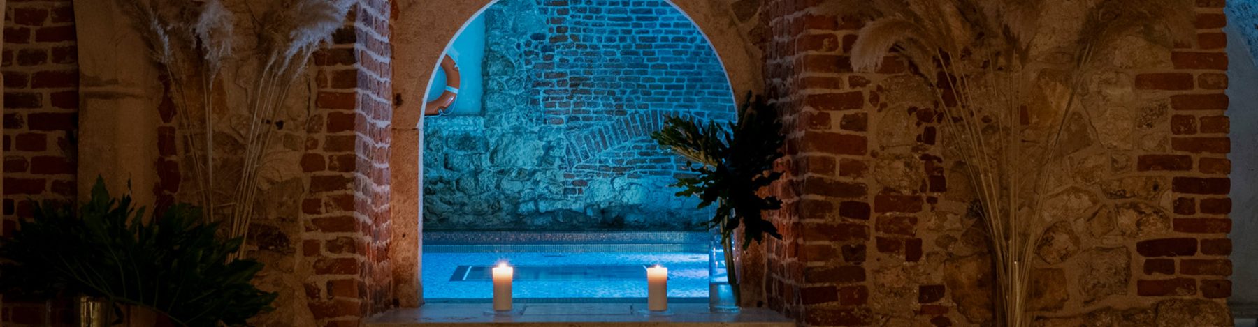 Pool water seen through a brick arch at Hotel Stary.