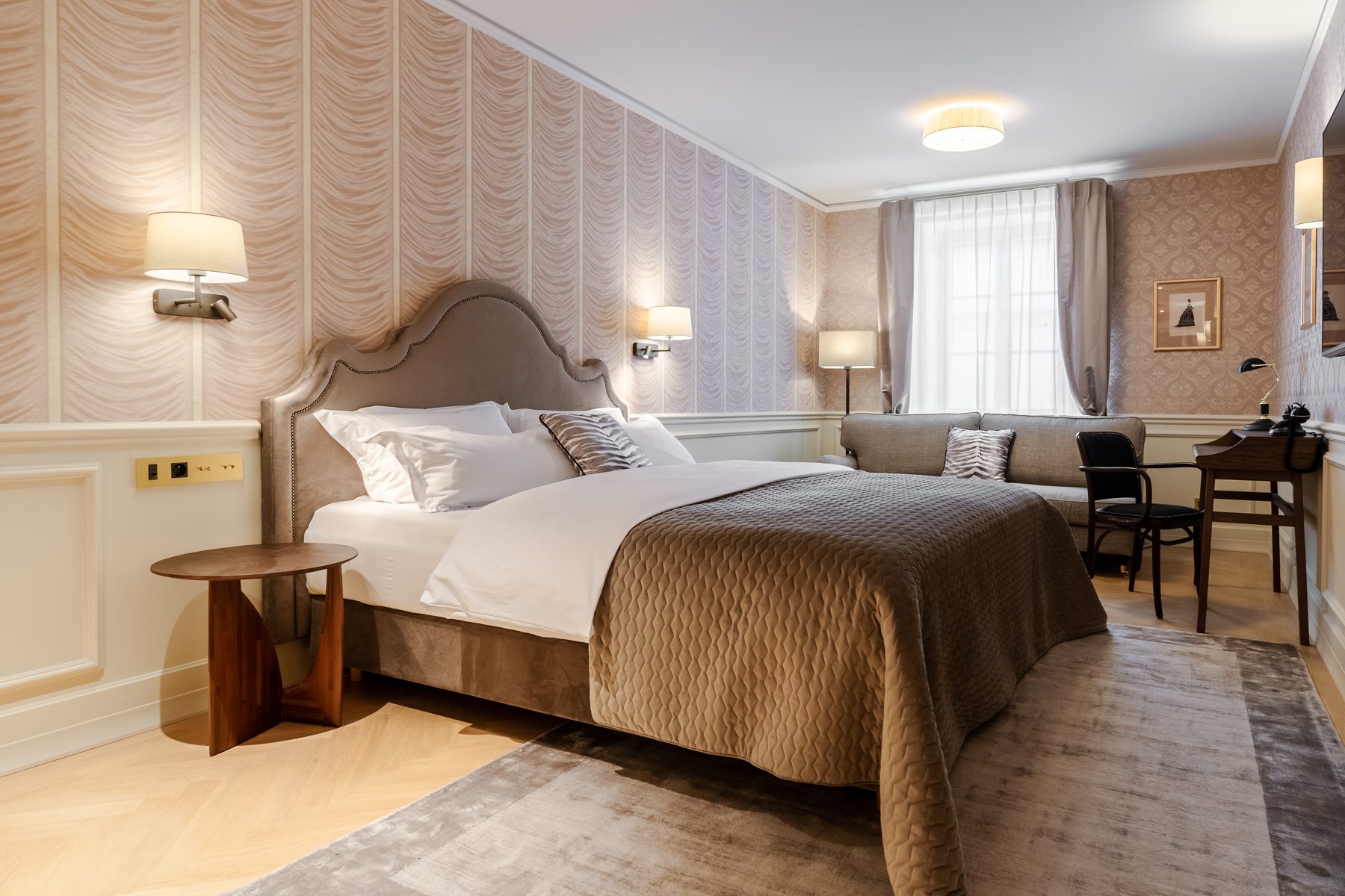 Unicus Palace Superior bedroom with a curved headboard and seating.
