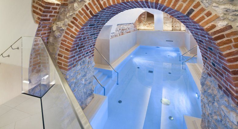 Indoor pool beneath brick arches at Wyndham Grand Krakow Old Town.