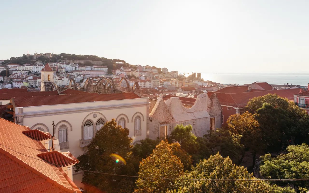 Carmo church ruins, red roofs and the distant castle hill in Lisbon.