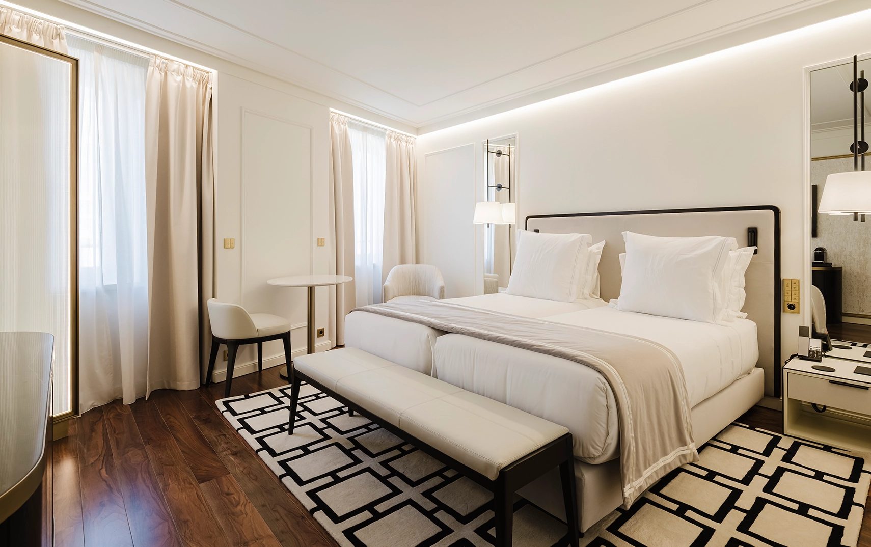 Classic bedroom at Lisbon Chiado Hotel & Spa with a padded bench, patterned rug and window seating.