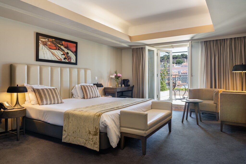 Premium bedroom at Hotel do Chiado with armchairs and an open terrace door.