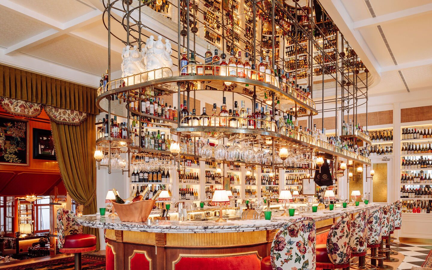 Rocco’s central bar with overhead bottle displays and patterned bar chairs at The Ivens.