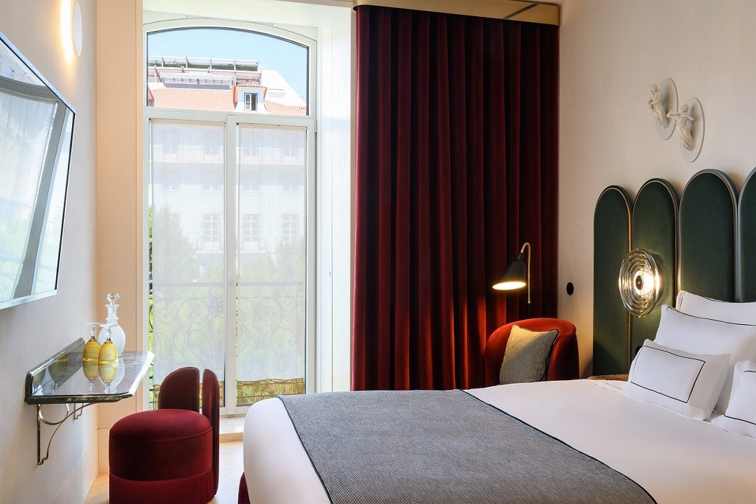 Vista Alegre Double Room with green headboard, red curtains and decorative wall lights.