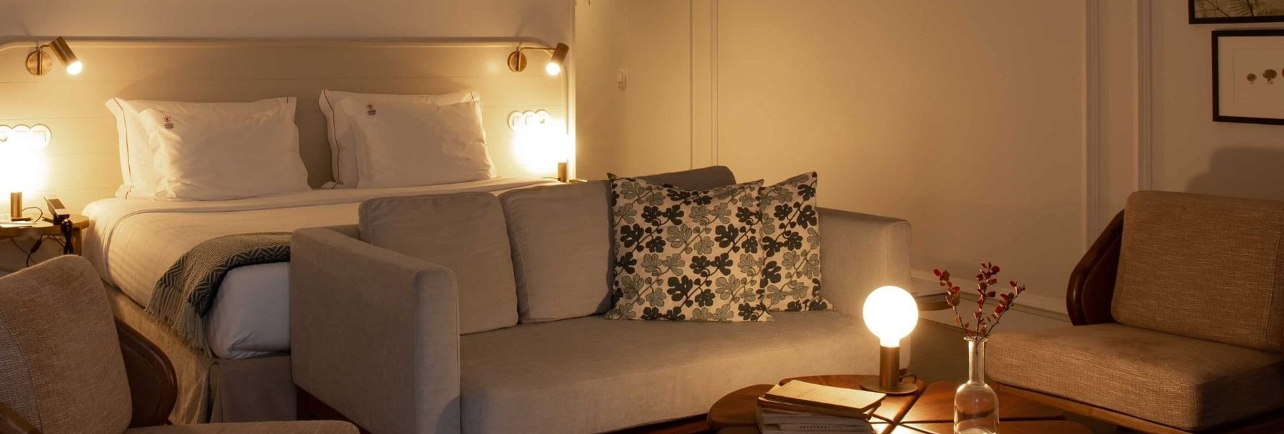 Sofa and armchairs in front of the bed in a Lisboa Pessoa Unique Double Room.