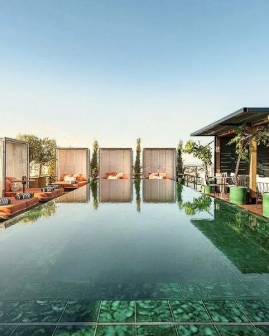 Emerald-tiled rooftop swimming pool and cabanas at BLESS Madrid.
