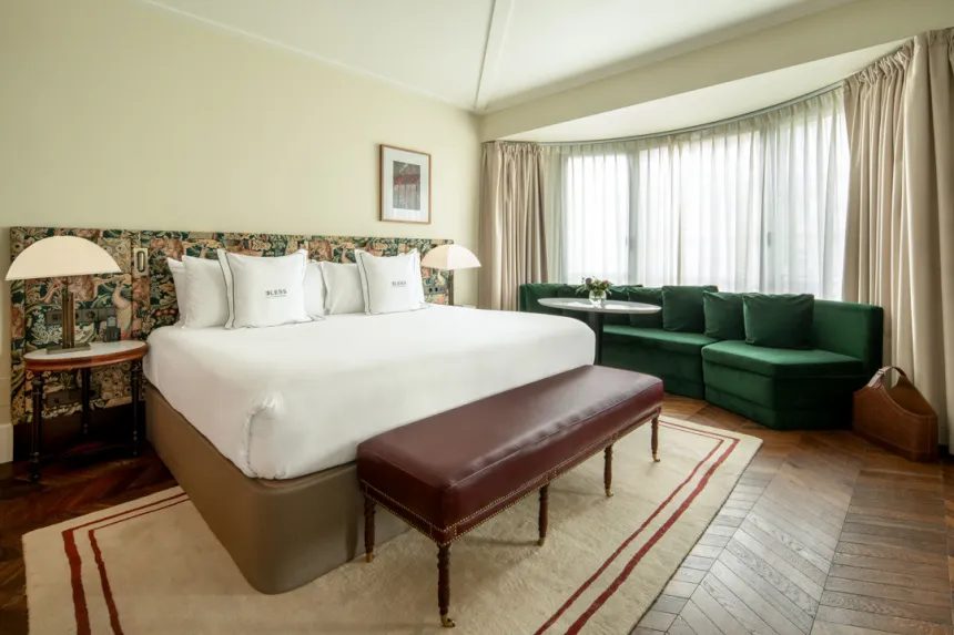 Premium Velázquez View bedroom with green window-side sofa at BLESS Madrid.