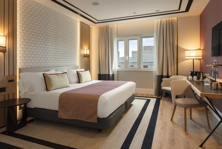 Superior Gran Vía View bedroom with desk and broad window at Catalonia Plaza España.