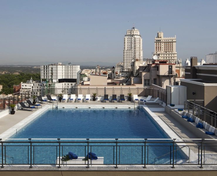 Rectangular rooftop swimming pool and sunbeds at Hotel Emperador.