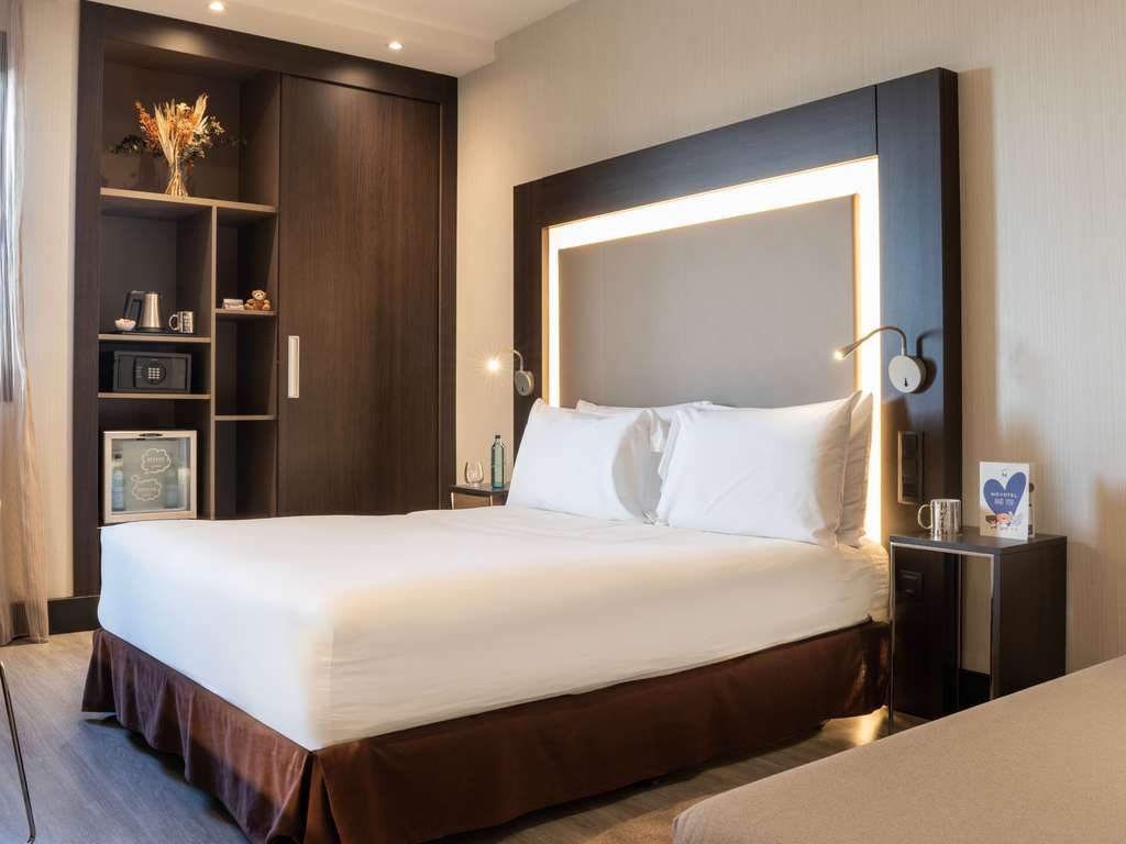 Standard queen bedroom with illuminated headboard at Novotel Madrid Center.