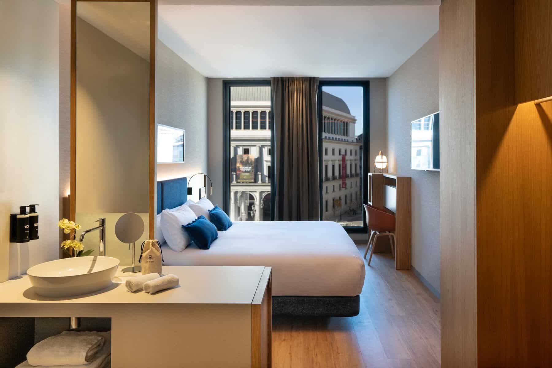 Ocean Drive Madrid Deluxe Plaza View bedroom with window towards Teatro Real.