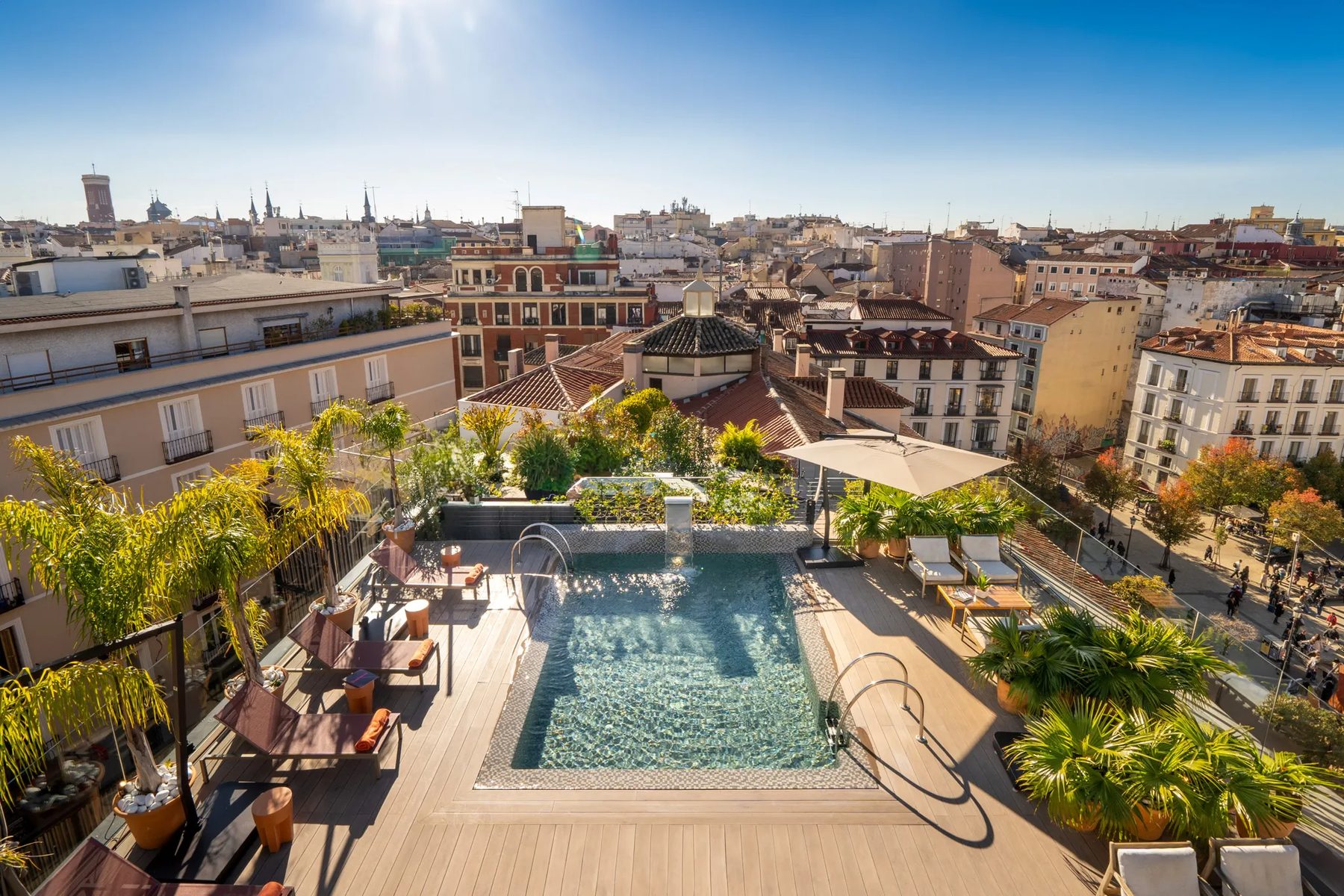 Compact rooftop pool with handrails, palms and Madrid skyline at Ocean Drive Madrid.