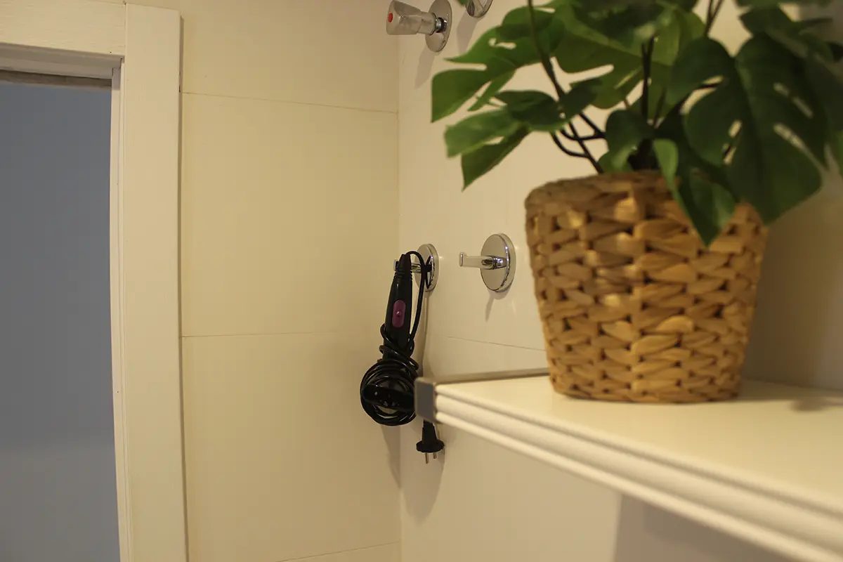 Hairdryer and towel rail in a pale-coloured bathroom.