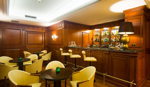 Wood-panelled bar with stools and small seating tables.