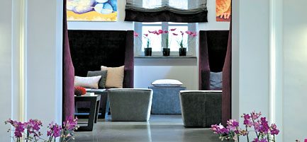 Upholstered seats arranged beneath coloured window panels.