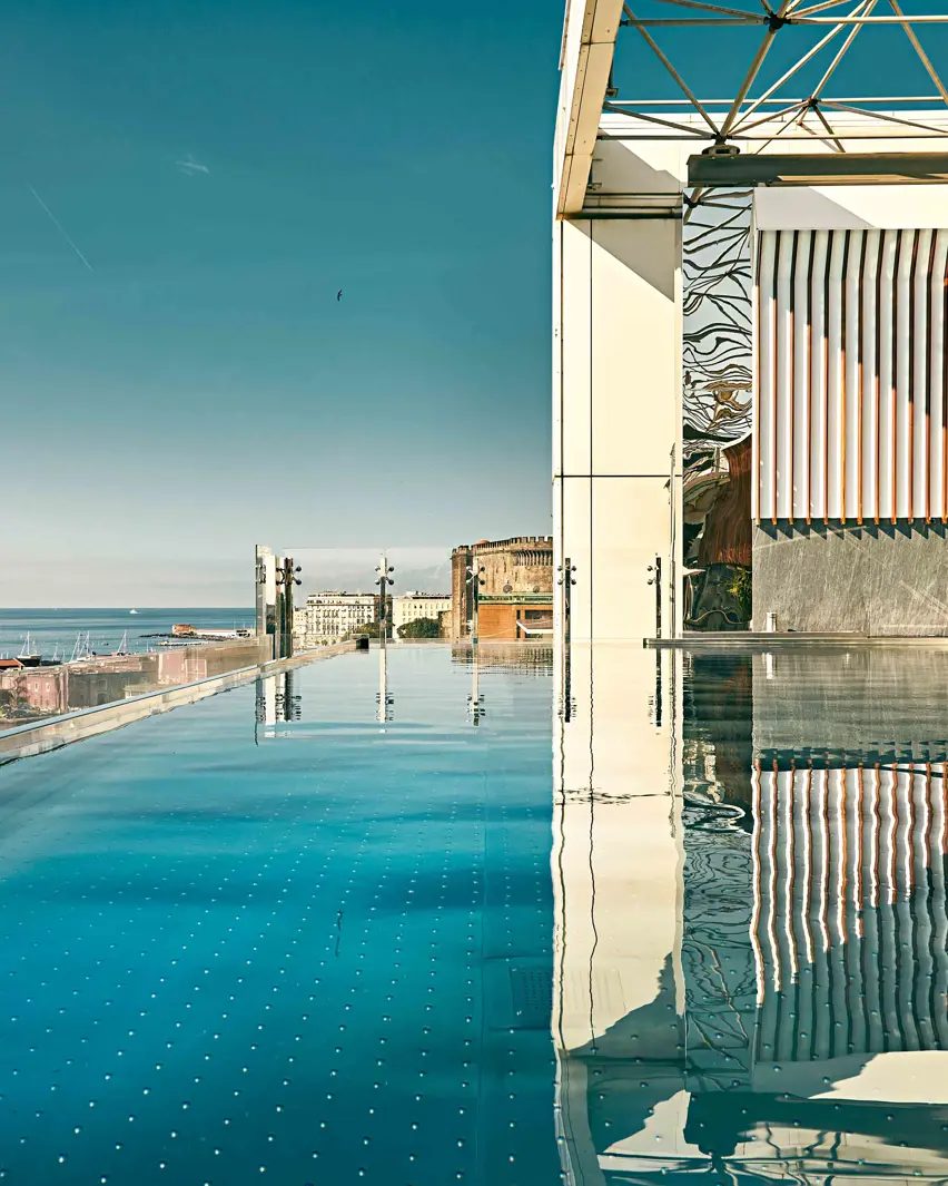 Rooftop infinity pool beside a covered terrace overlooking the harbour.