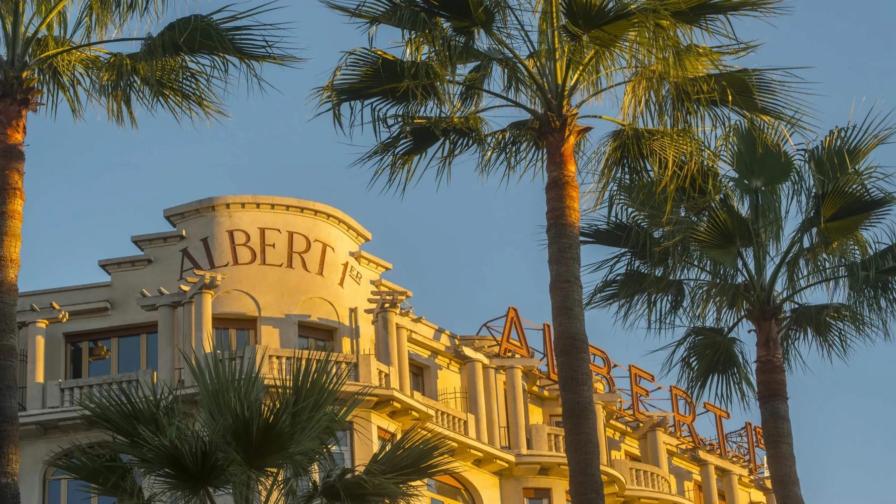 Albert 1er hotel façade and sign framed by palm trees