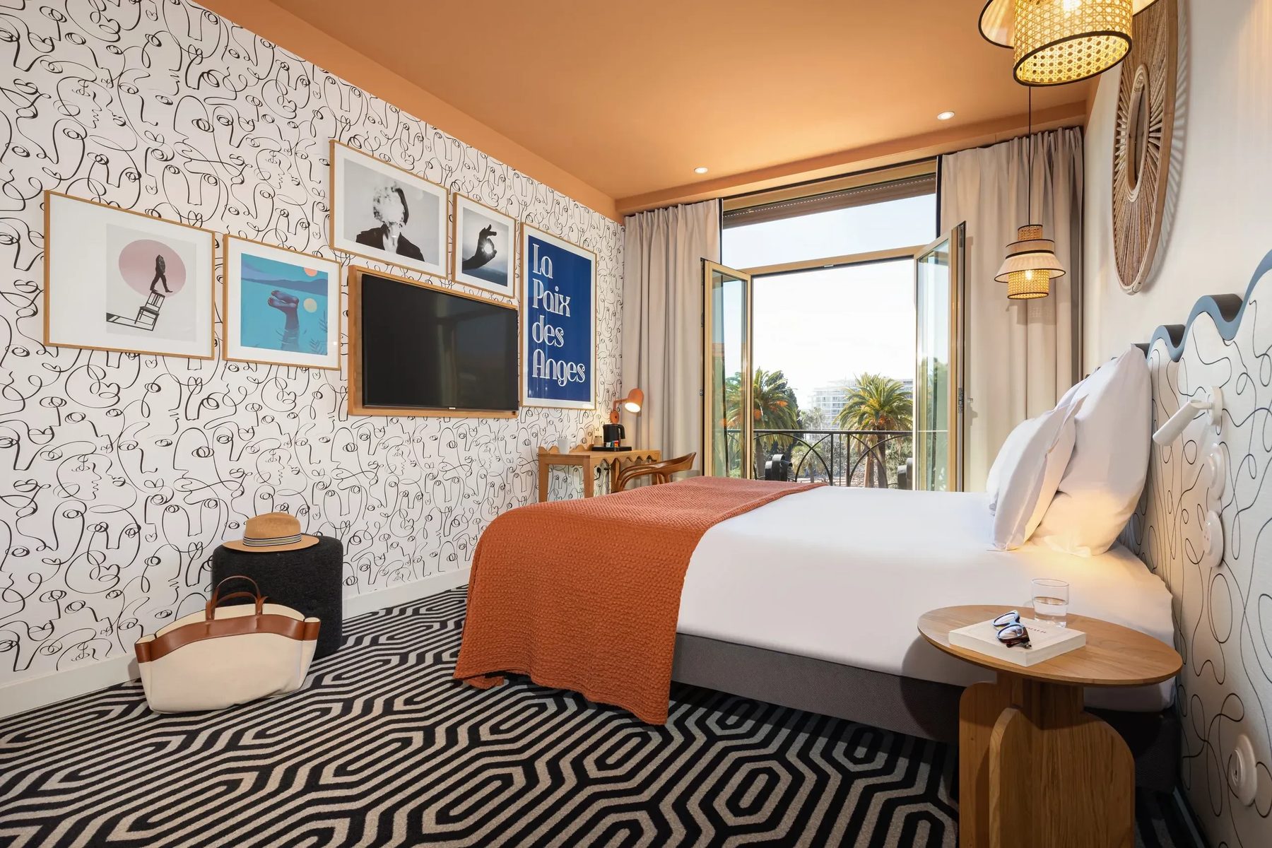 Bed with orange cover and patterned carpet in an Albert 1er Superior Sea View room