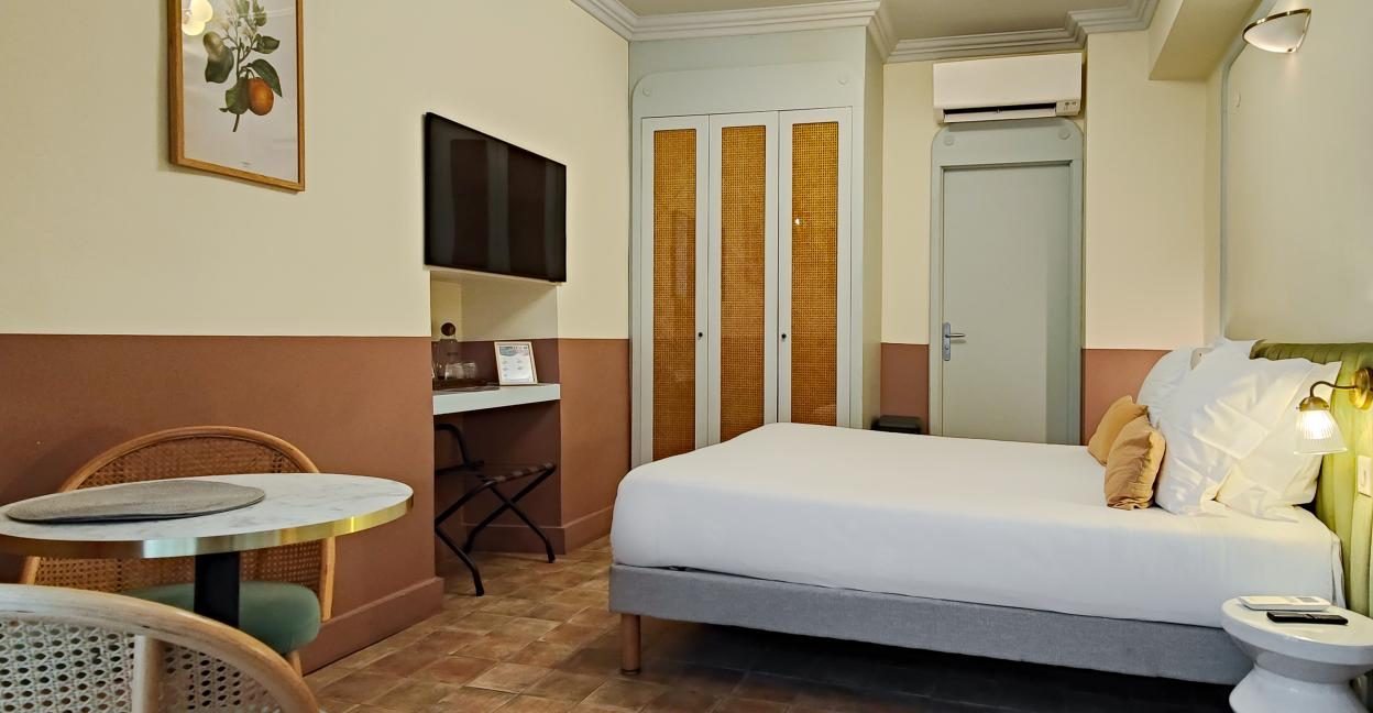 Bed and small dining table in a Studio Standard Plus at AMMI Vieux Nice