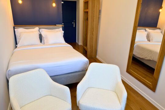 Double bed, mirror and two armchairs in a Supérieure vue Masséna room