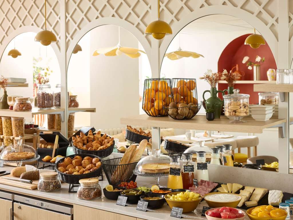 Breakfast buffet with pastries, fruit and juice beneath decorative arches