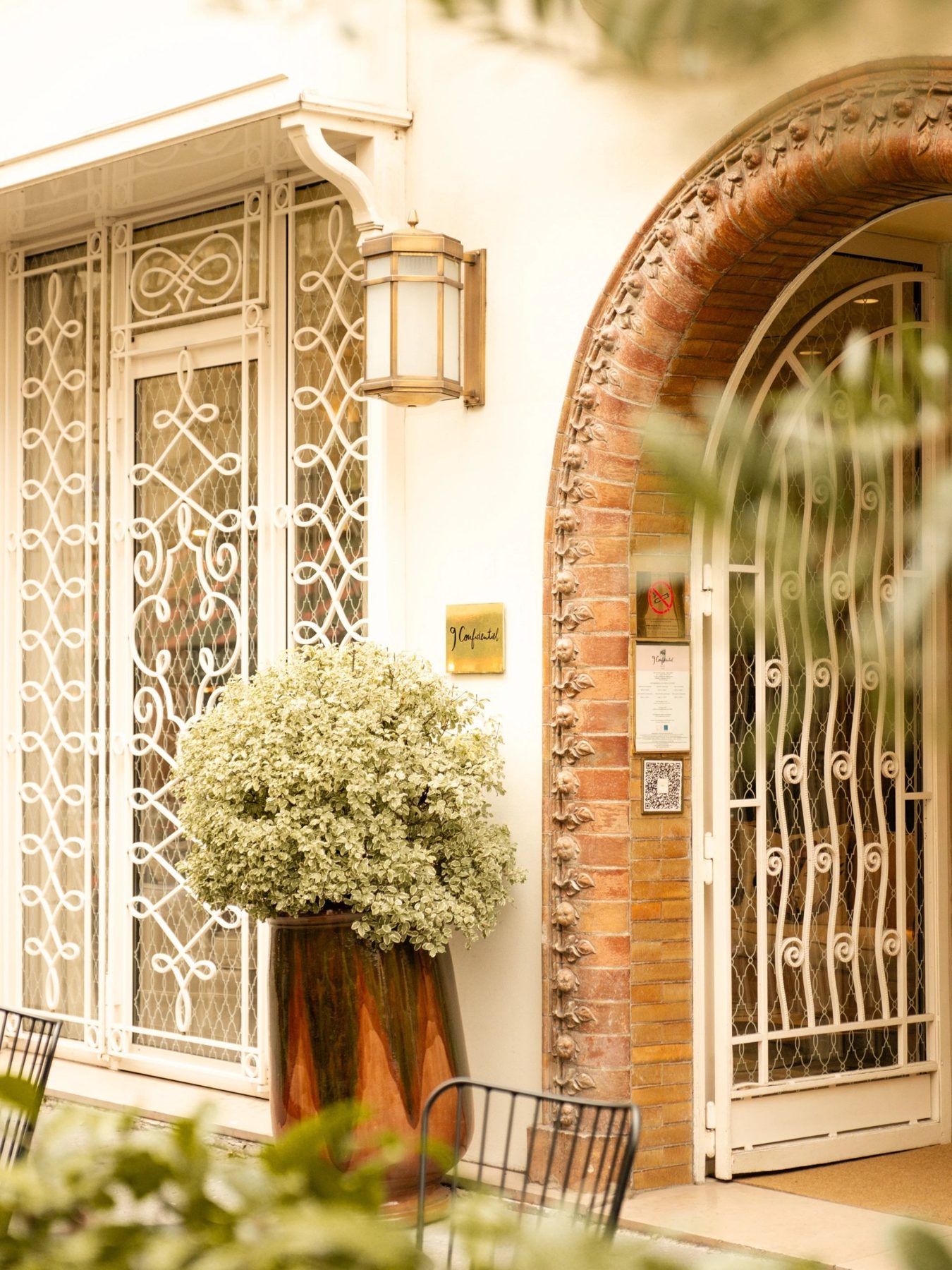 Arched brickwork, white metal gates and planting at 9Hôtel Confidentiel.