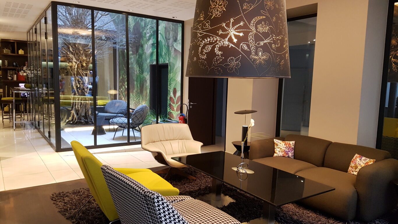 Colourful lounge seating beside a glazed courtyard at Hôtel Duo.