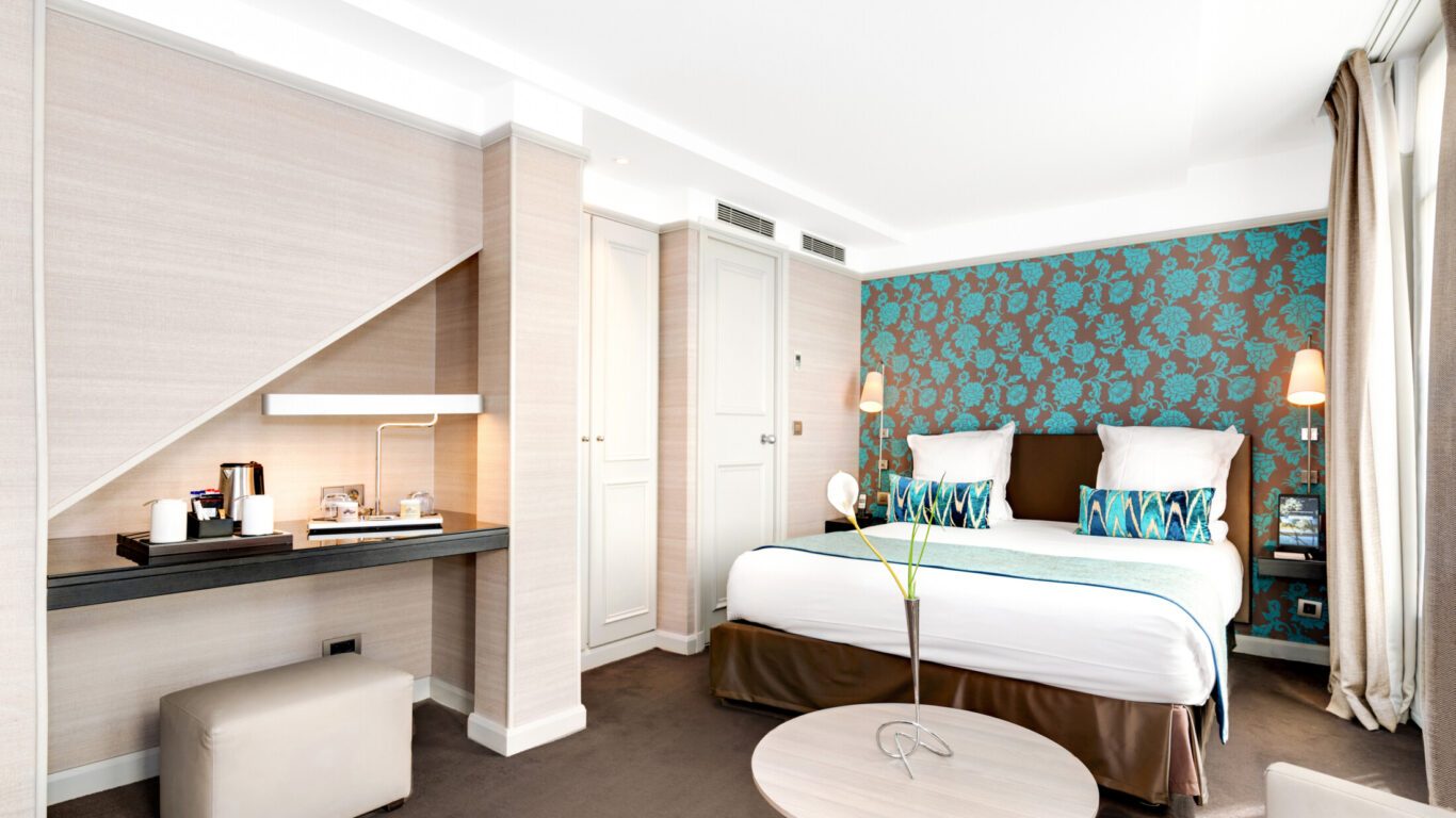 Deluxe bedroom with teal floral headboard wall at Hôtel Duo.