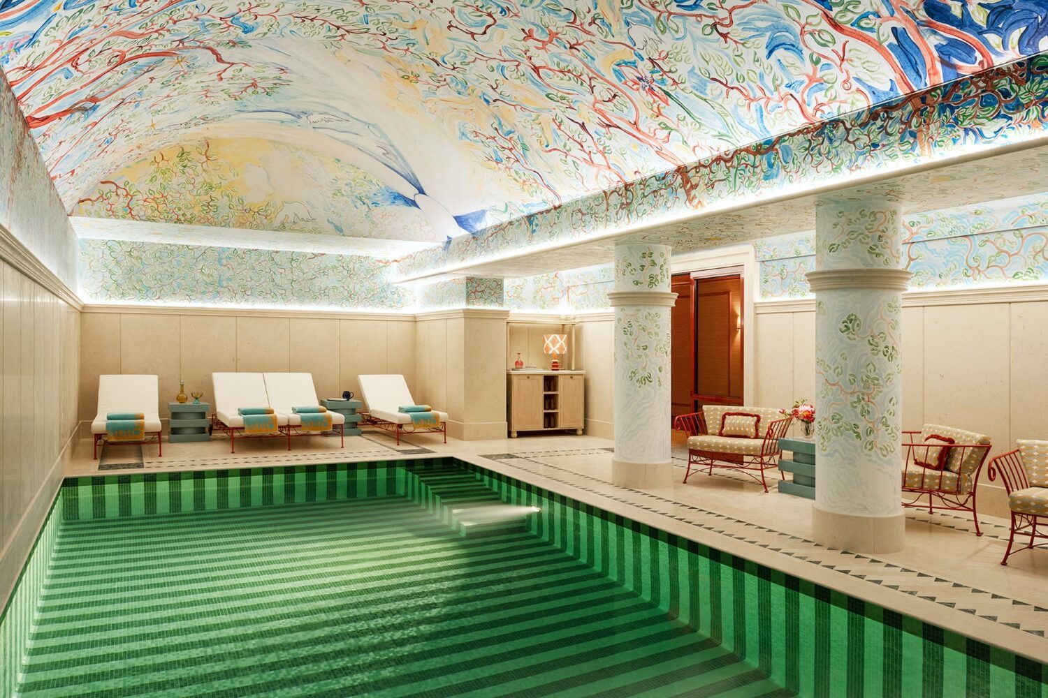Green-striped indoor pool beneath a painted ceiling at Le Grand Mazarin.