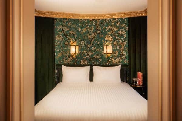 White bed in a green floral alcove at Maison Proust.