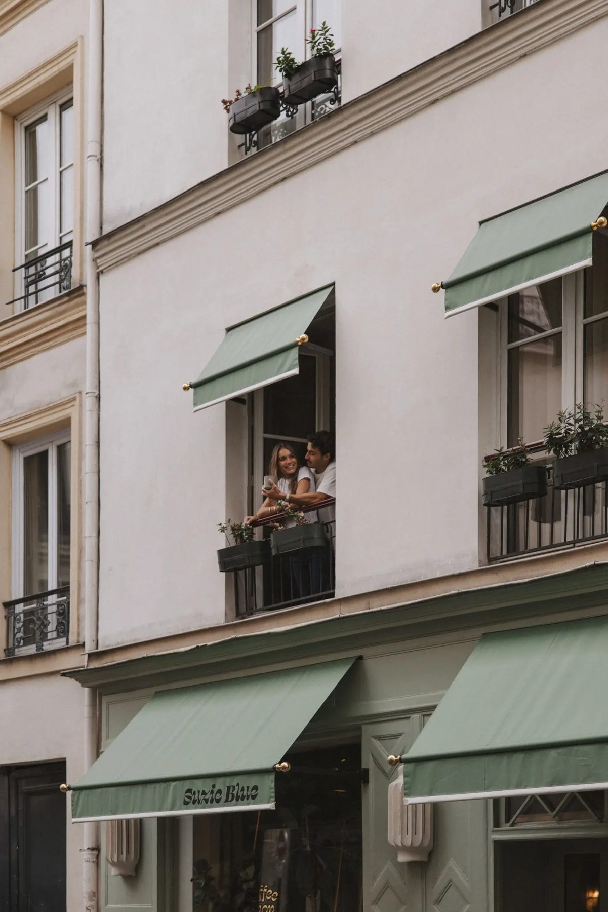 Green awnings and the façade of Hôtel Suzie Blue.
