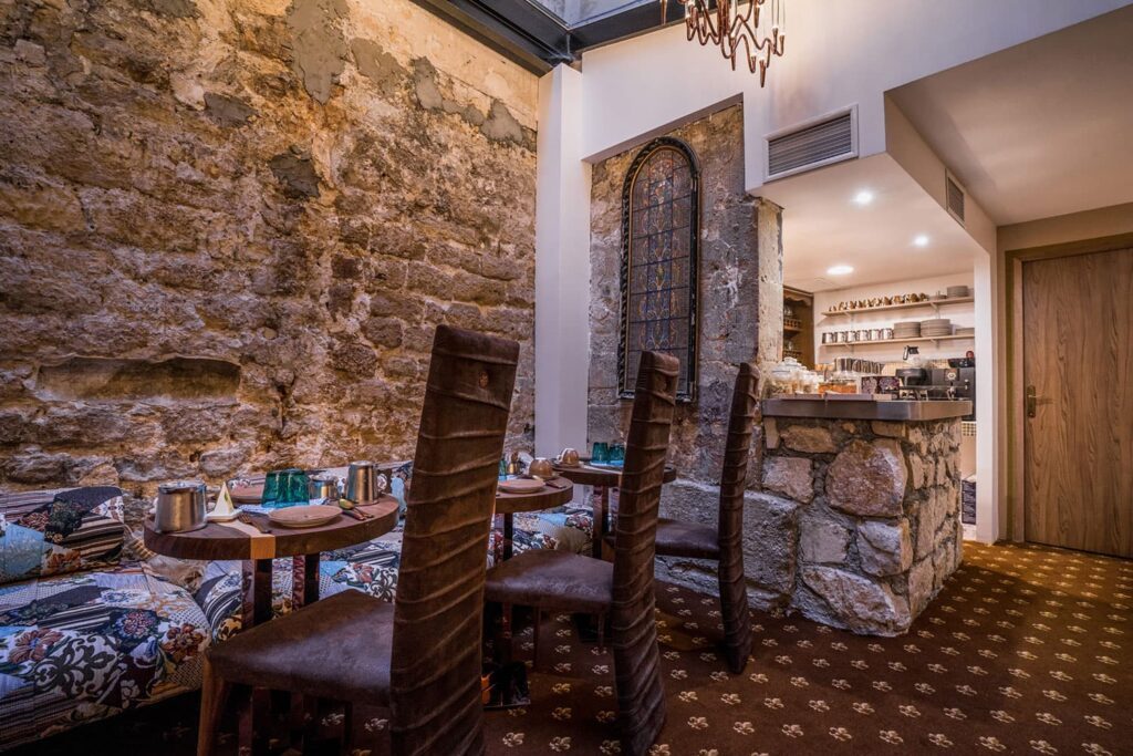 Stone walls, set tables and a breakfast counter at Le Temple de Jeanne.