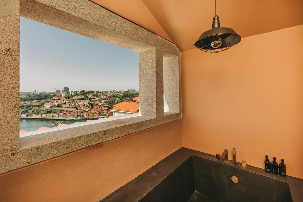 Bath beneath a wide river-facing window with dark hanging lamp at Torel Avantgarde.