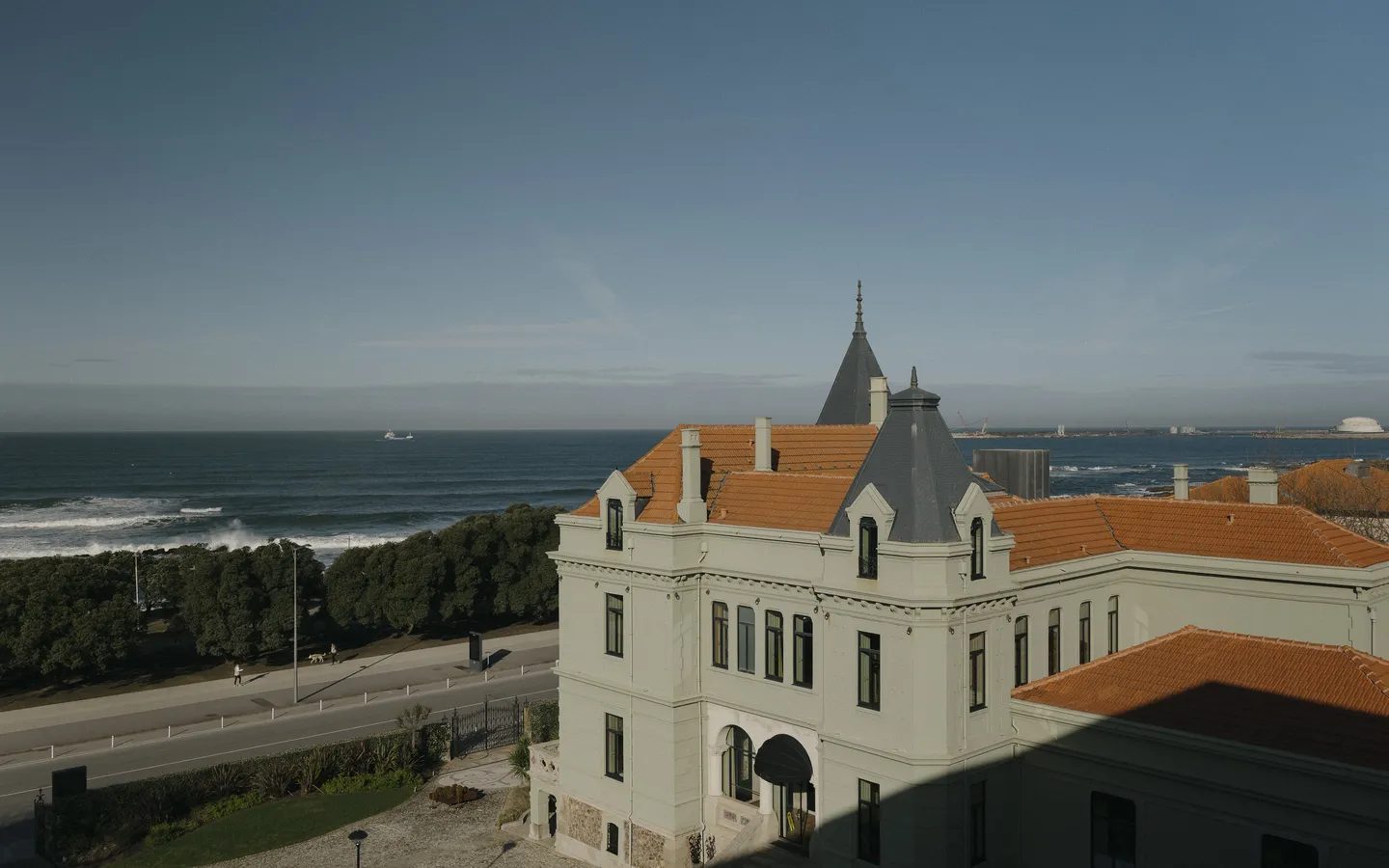 Historic Vila Foz manor, orange roof and oceanfront road with Atlantic beyond.