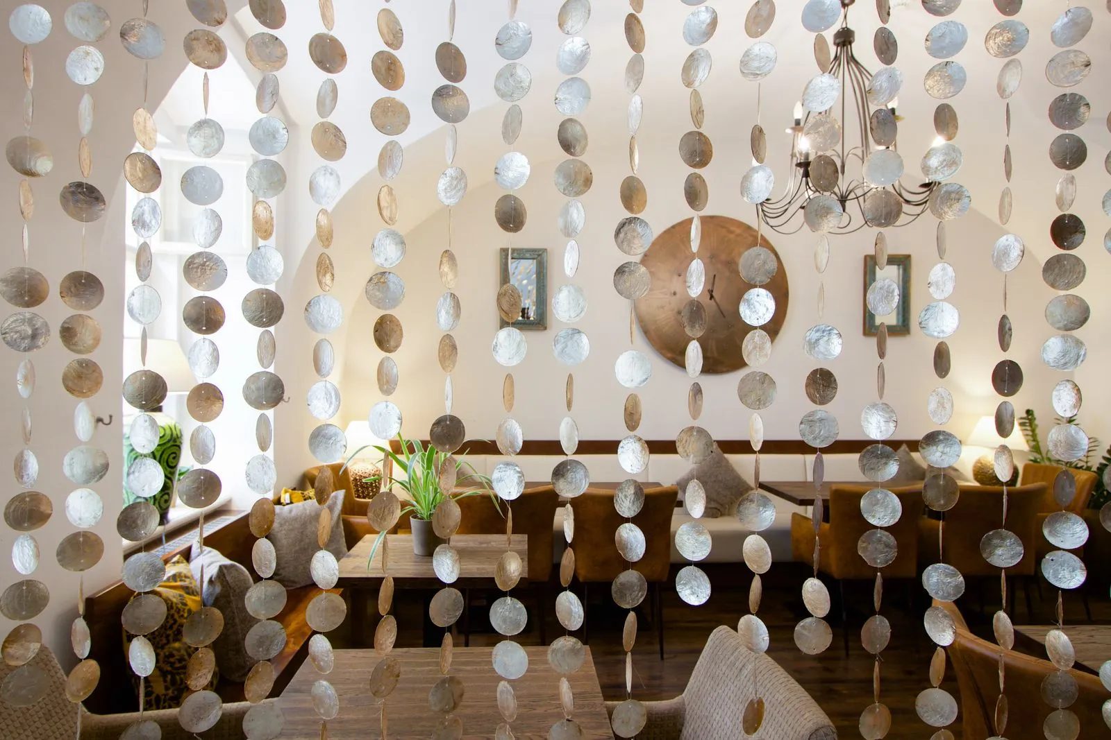 Breakfast tables and chairs behind a decorative hanging screen.