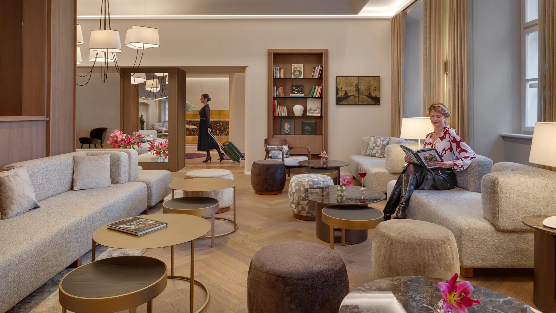 Lobby with sofas, upholstered chairs, bookshelves and flower arrangements.