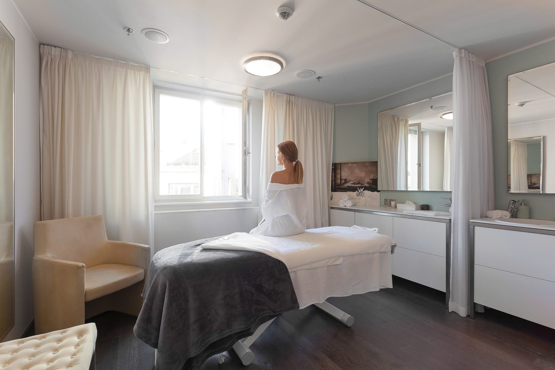 M Spa treatment room with a massage bed and seating.
